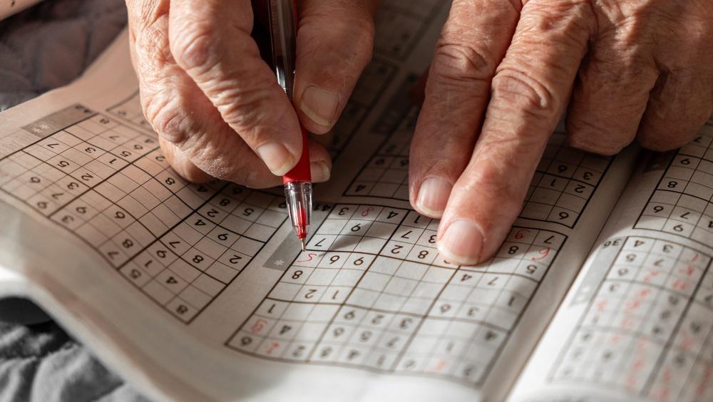 en gammal kvinna som löser Sudoku från Morgontidningen